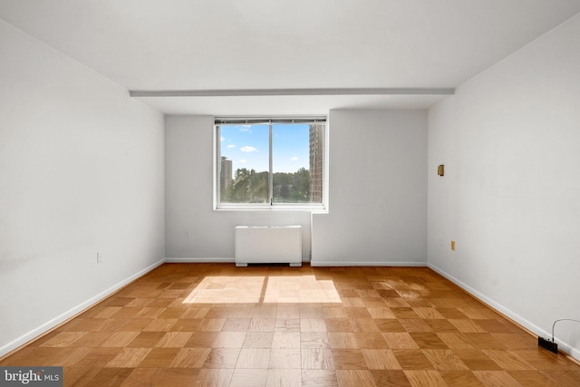 unfurnished room featuring radiator heating unit and baseboards