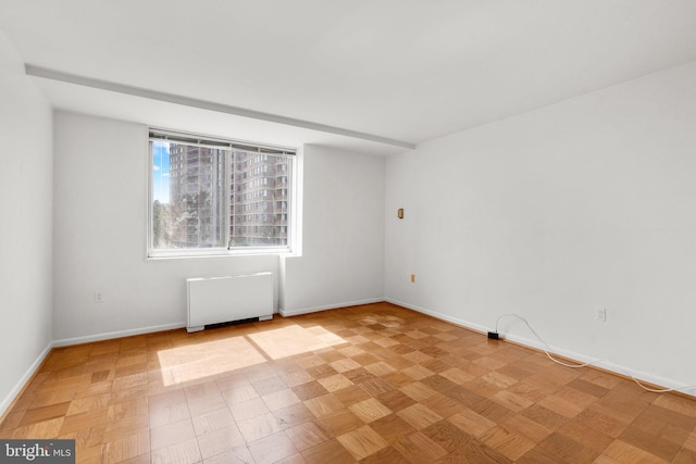 empty room with baseboards and radiator heating unit