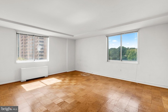 spare room with baseboards and radiator