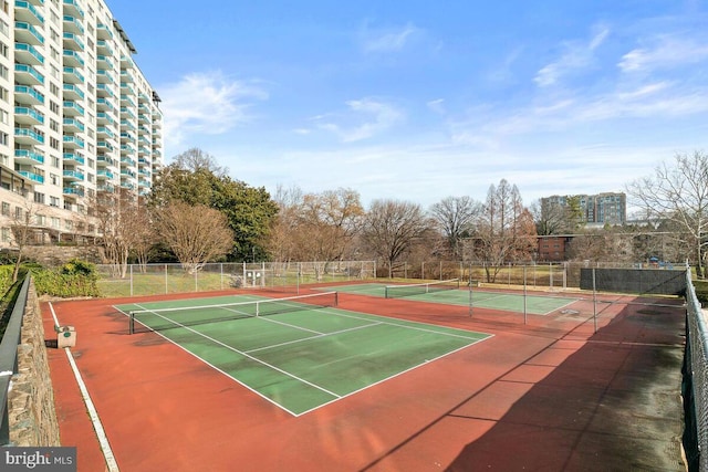 view of tennis court with community basketball court and fence