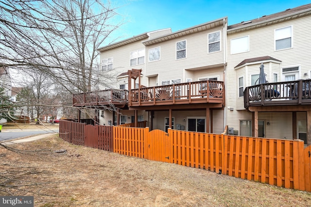 rear view of house featuring a fenced front yard and a gate