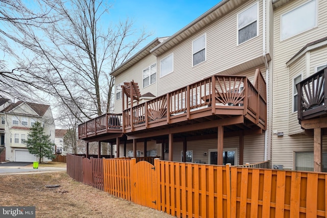 rear view of property featuring fence private yard, a deck, and a gate