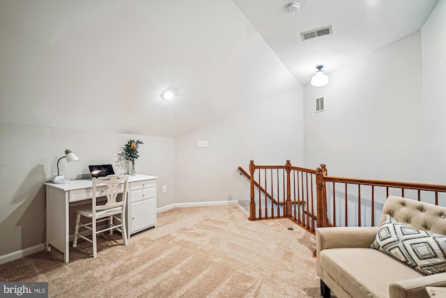 office space featuring visible vents, lofted ceiling, light colored carpet, and baseboards