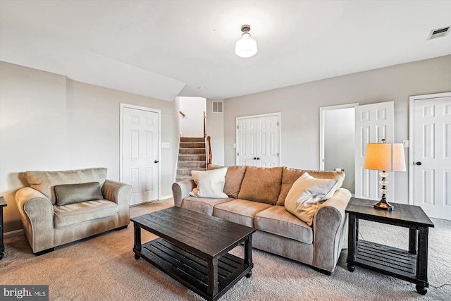 carpeted living area featuring visible vents and stairs