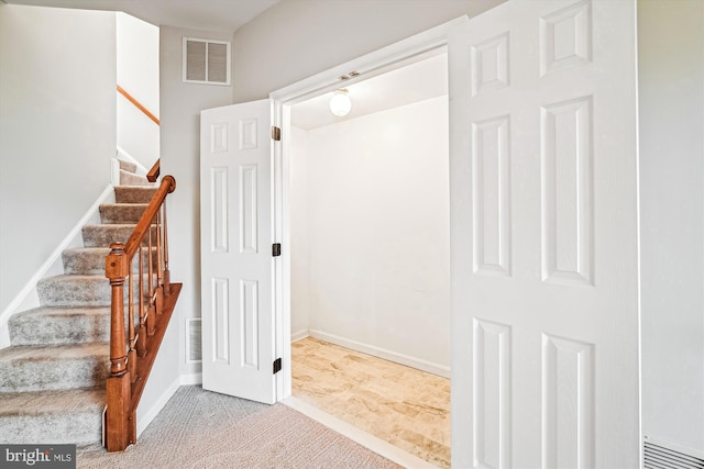 stairway with carpet flooring, baseboards, and visible vents