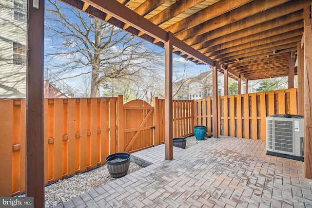 view of patio / terrace featuring central air condition unit, fence, and a gate