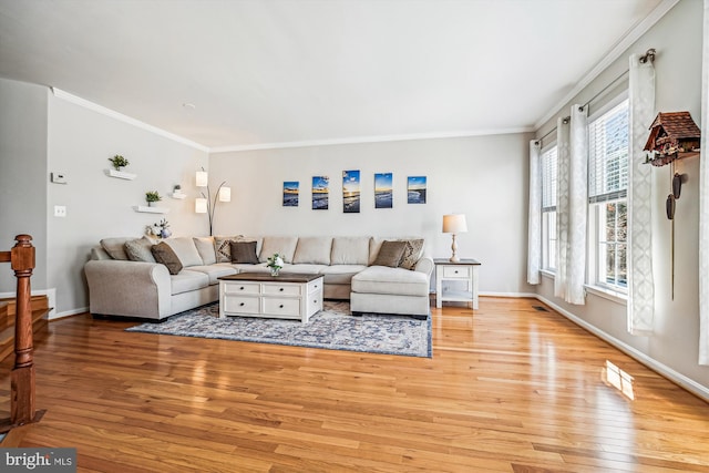 living area featuring light wood-style flooring, baseboards, and ornamental molding