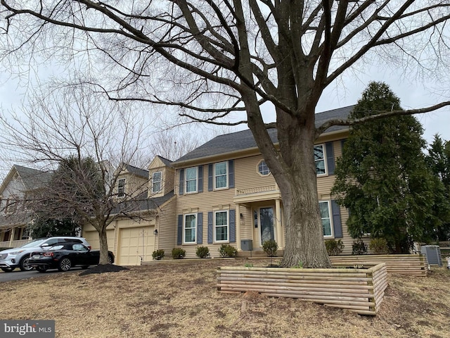 colonial inspired home with a garage and driveway