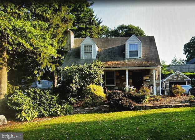 new england style home with a chimney and a front lawn