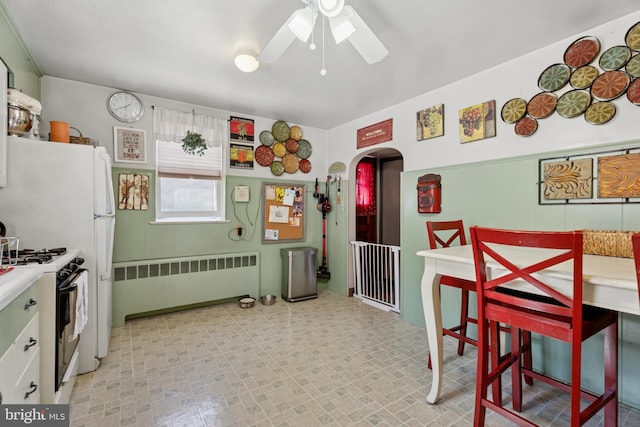 kitchen featuring range with gas stovetop, radiator, arched walkways, and ceiling fan