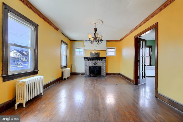 unfurnished living room with dark wood-style floors, radiator heating unit, ornamental molding, and baseboards