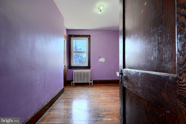 interior space featuring baseboards, wood-type flooring, and radiator