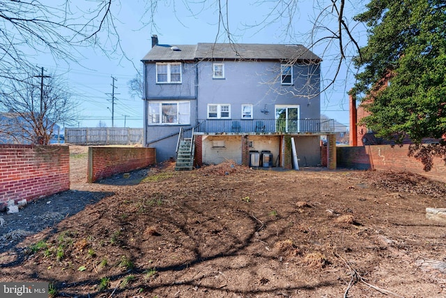 rear view of house with a deck, a chimney, fence, and stairway