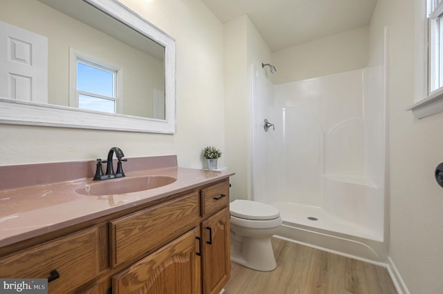 full bathroom featuring wood finished floors, walk in shower, vanity, and toilet