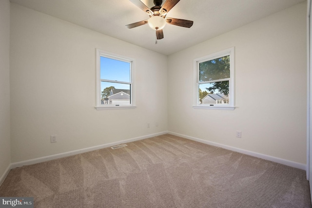 empty room featuring carpet, visible vents, ceiling fan, and baseboards