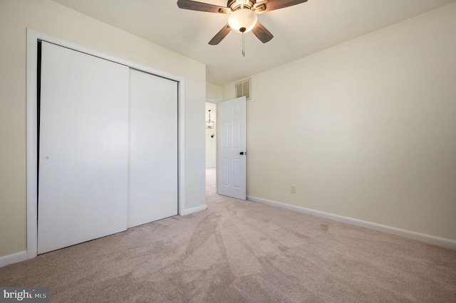 unfurnished bedroom with light carpet, baseboards, visible vents, ceiling fan, and a closet