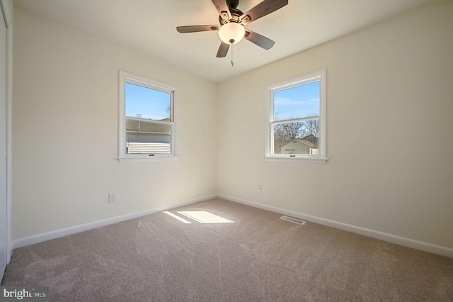 unfurnished room featuring carpet, visible vents, ceiling fan, and baseboards