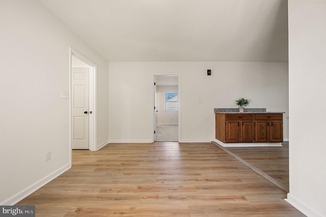 interior space with baseboards and light wood finished floors