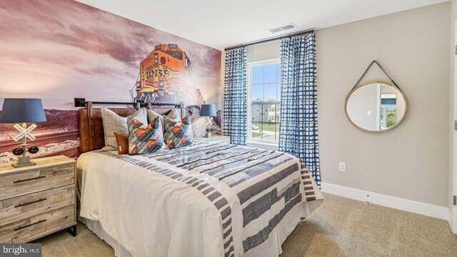 bedroom featuring visible vents, light carpet, and baseboards