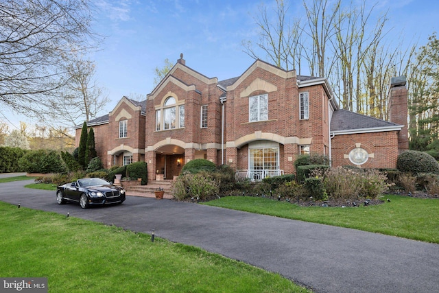 7707 Carlton Pl, Mclean, VA 22102 - view of front facade with a front lawn, driveway, a chimney, and brick siding