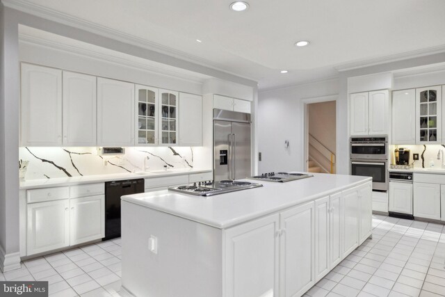 7707 Carlton Pl, Mclean, VA 22102 - kitchen featuring white cabinetry, backsplash, stainless steel appliances, and a center island