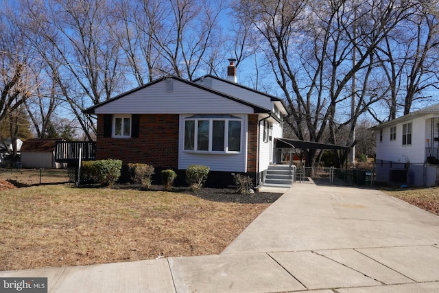 view of front of home with driveway, fence, a carport, and brick siding