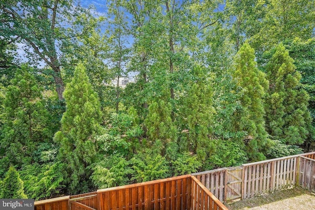 wooden deck with a fenced backyard