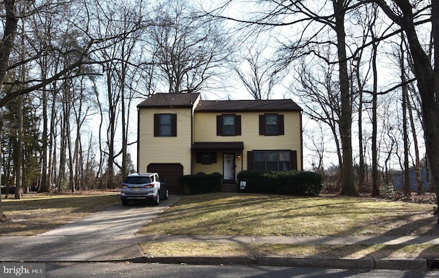 view of front of house featuring a garage, a front yard, and concrete driveway