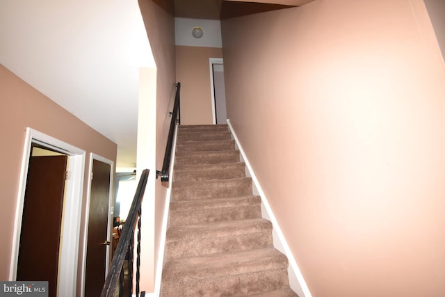 stairs with carpet floors and baseboards