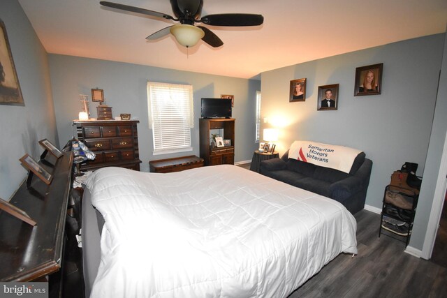 bedroom featuring ceiling fan, dark wood-style flooring, and baseboards