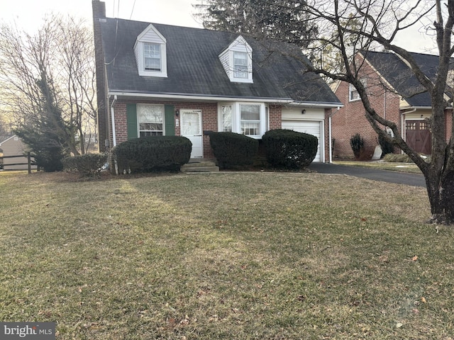 new england style home with a garage, driveway, brick siding, and a front lawn