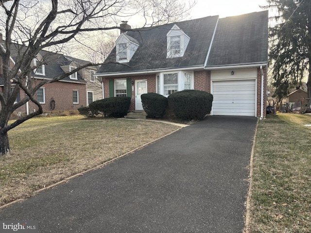 cape cod house with a garage, driveway, brick siding, a chimney, and a front yard