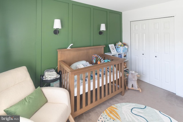 bedroom featuring light carpet, a decorative wall, and a closet