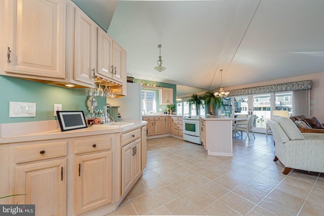 kitchen featuring light countertops, open floor plan, a sink, white appliances, and a peninsula