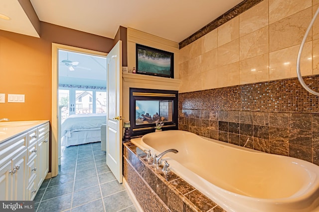 ensuite bathroom featuring ceiling fan, ensuite bathroom, tile patterned flooring, vanity, and a bath