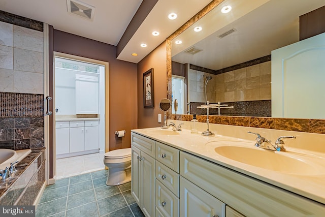 bathroom featuring a tile shower, a sink, and visible vents