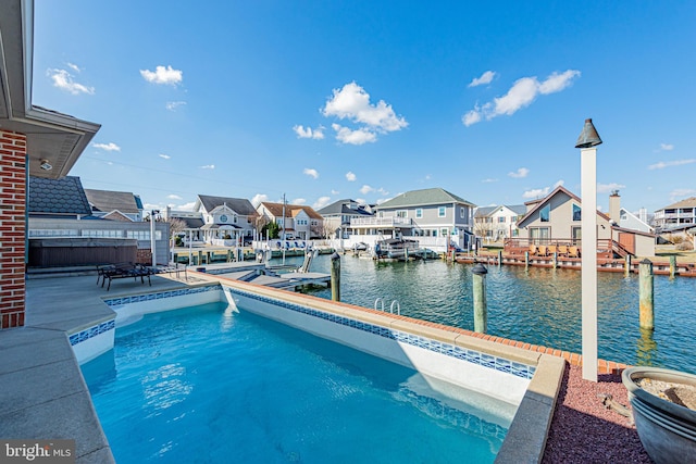 view of swimming pool featuring a dock, a water view, a patio area, and a residential view