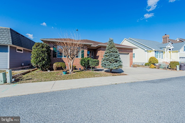 view of front of house with driveway, brick siding, and an attached garage