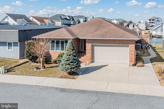 ranch-style house featuring brick siding, a shingled roof, a garage, a residential view, and driveway