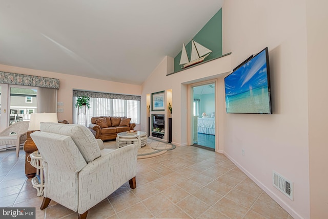 living room featuring light tile patterned floors, plenty of natural light, a fireplace, and visible vents