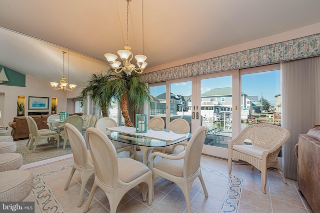 dining space featuring light tile patterned floors, a residential view, an inviting chandelier, vaulted ceiling, and french doors