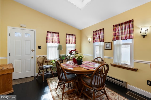 dining room featuring dark wood-style floors, vaulted ceiling with skylight, visible vents, and baseboards