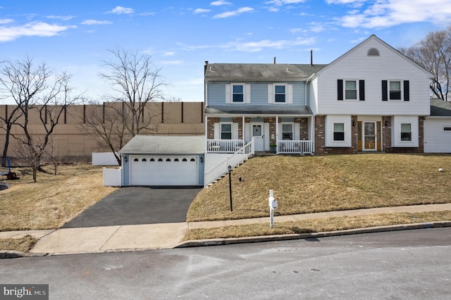 view of front of house featuring brick siding, a porch, an attached garage, driveway, and a front lawn