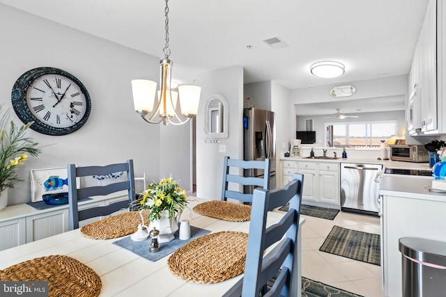 dining room with light tile patterned flooring, visible vents, and ceiling fan with notable chandelier