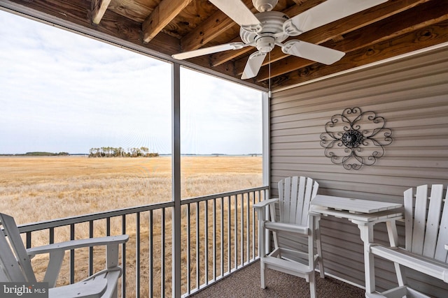 balcony featuring ceiling fan and a rural view