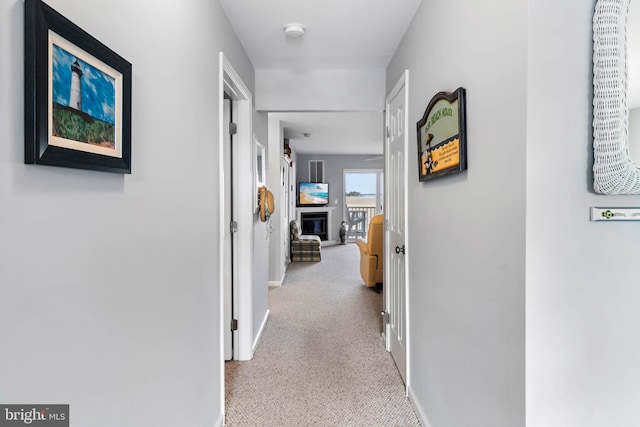 corridor featuring baseboards and carpet flooring