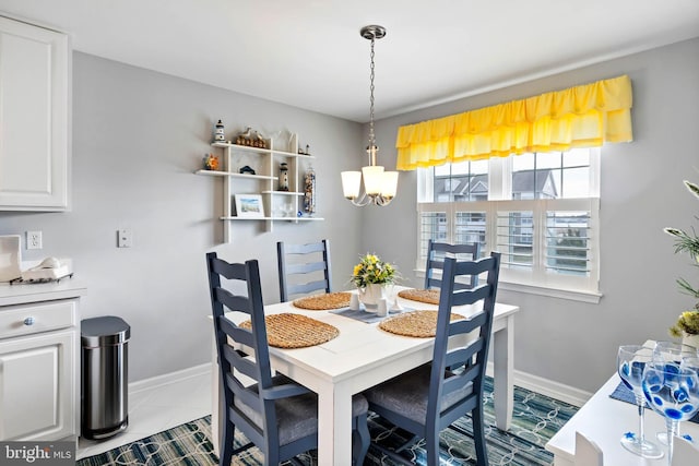 tiled dining room with a notable chandelier and baseboards