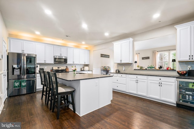 kitchen featuring stainless steel appliances, dark countertops, and white cabinets