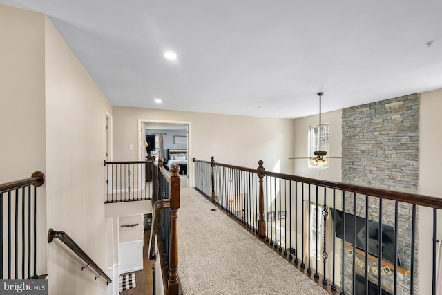 hall with carpet, an upstairs landing, and recessed lighting