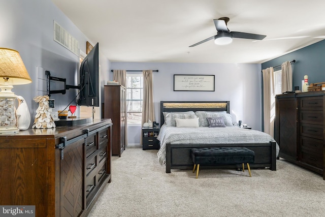 bedroom featuring visible vents, a ceiling fan, and light colored carpet